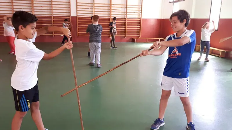 Dos niños jugando al palo canario